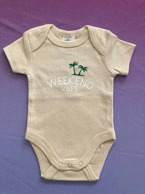 Beige baby bodysuit with 'WEEKEND VIBES' custom print and green palm tree design, soft cotton short-sleeve beach-themed infant onesie for summer by AJ's Infinity Design