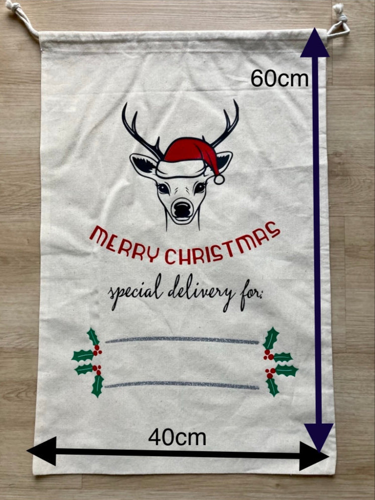 Personalized white canvas Santa sack with custom reindeer wearing Santa hat design, 'MERRY CHRISTMAS special delivery for' custom print, holly decoration and name space, reusable 40cm x 60cm Christmas gift bag with drawstring by AJ's Infinity Design
