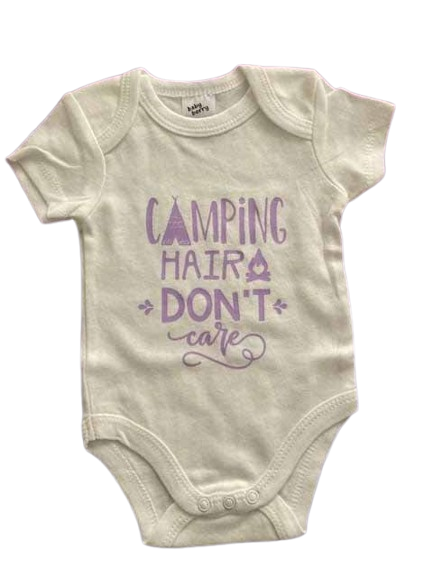 White cotton baby bodysuit with purple 'CAMPING HAIR DON'T CARE' custom print featuring teepee and campfire icons, short-sleeve outdoor adventure themed infant onesie for nature-loving families by AJ's Infinity Design